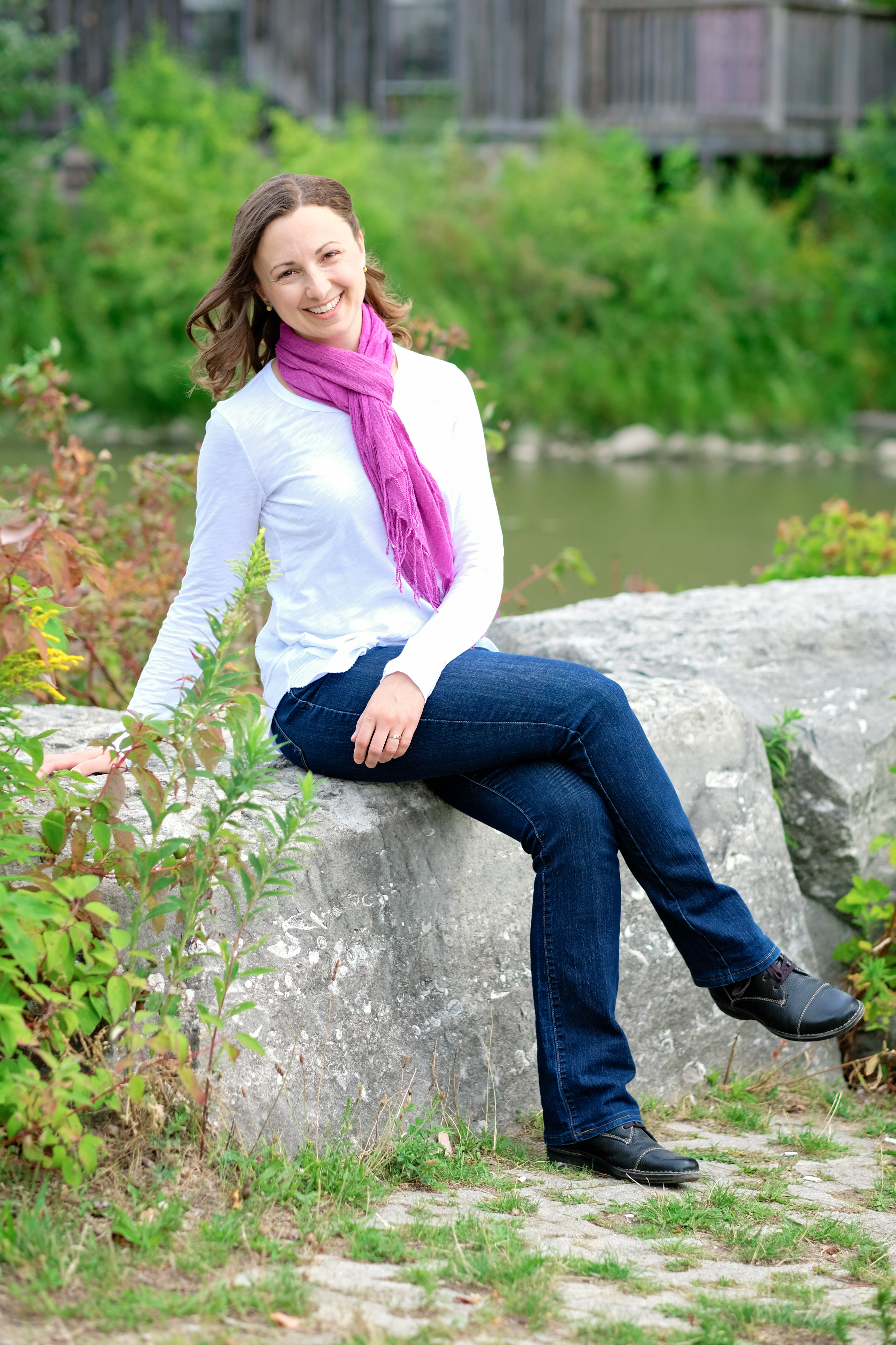 Canadian author Lori Wolf-Heffner sitting on a rock