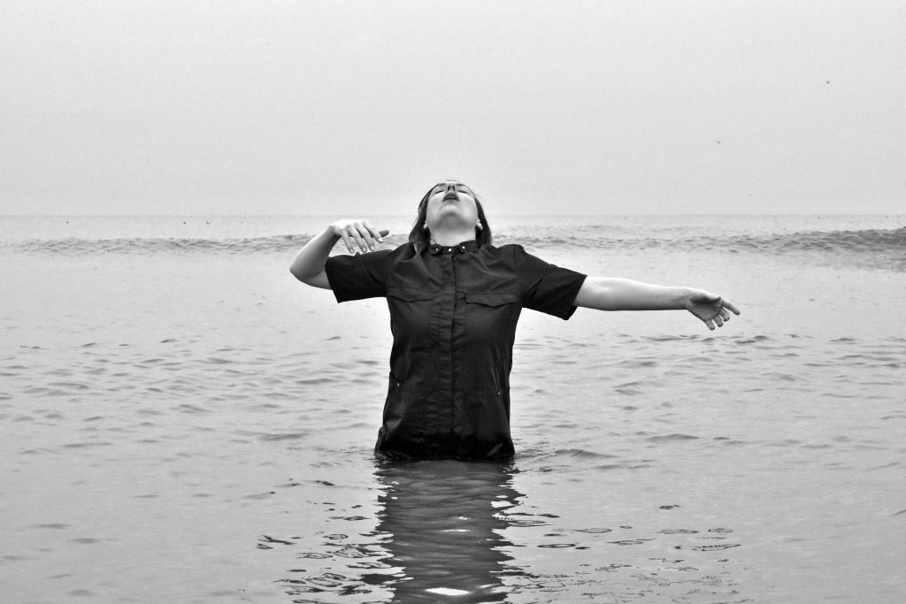 Kate Hilliard standing in a lake, taking a big breath
