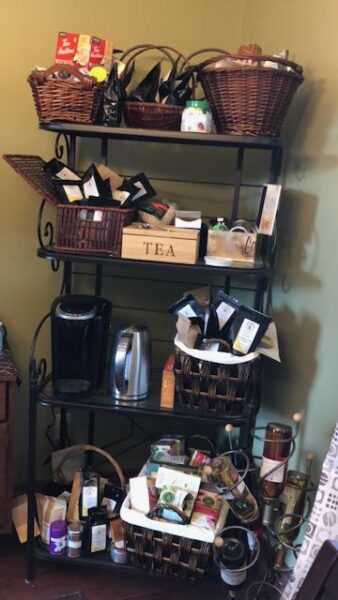 A 4-tier shelf with baskets of mostly tea. Also a kettle and a Keurig machine.